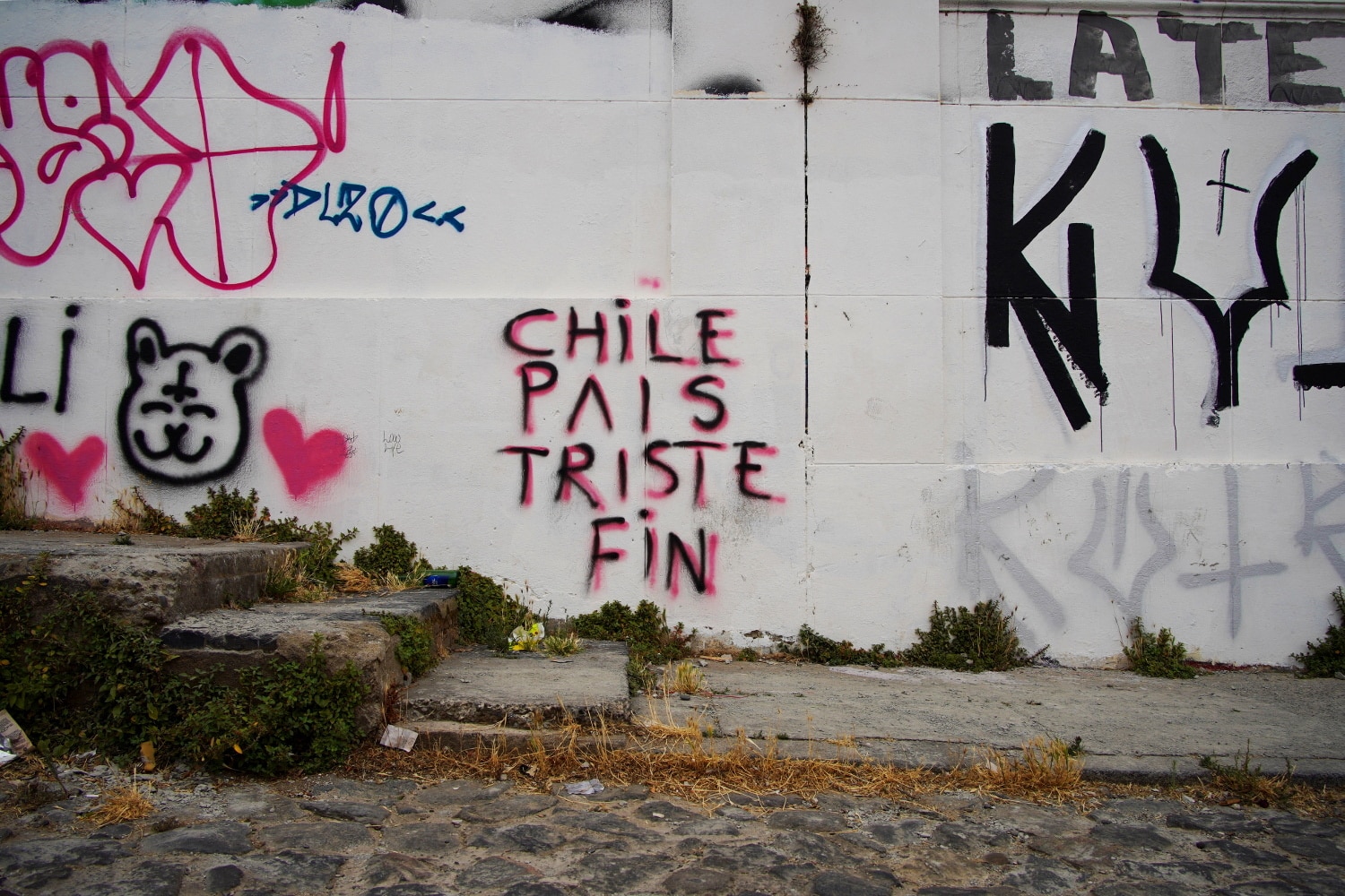 Un tag sur un mur qui porte l'inscription "Chile país triste" (Chili pays trsite)